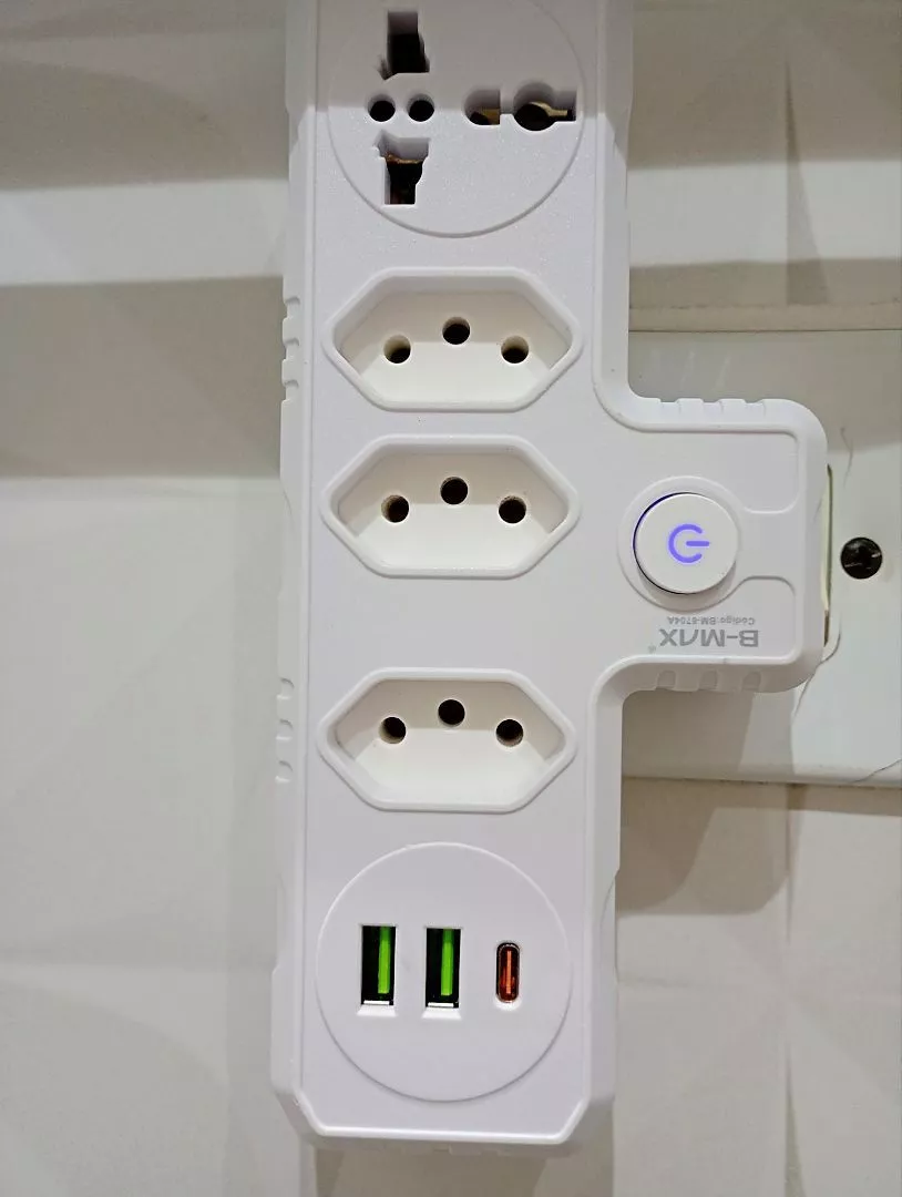 Adaptador com três tomadas e portas USB em uso