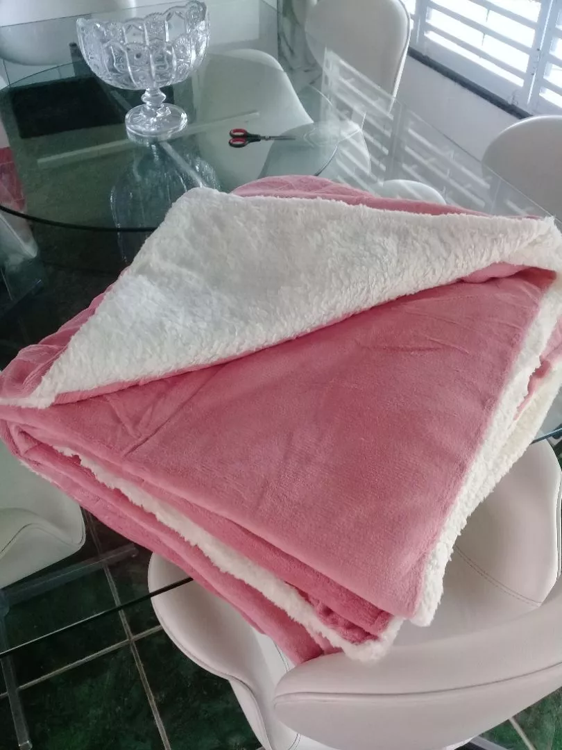 Coberdrom sherpa rosé dobrado mostrando as duas faces